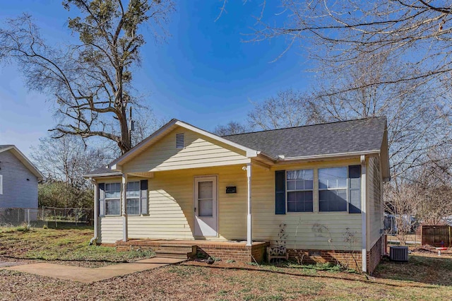 bungalow featuring central AC, crawl space, fence, and roof with shingles