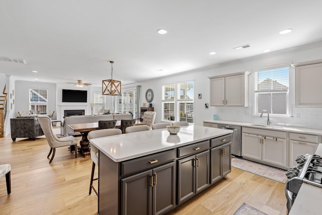 kitchen with visible vents, a fireplace, appliances with stainless steel finishes, and a breakfast bar