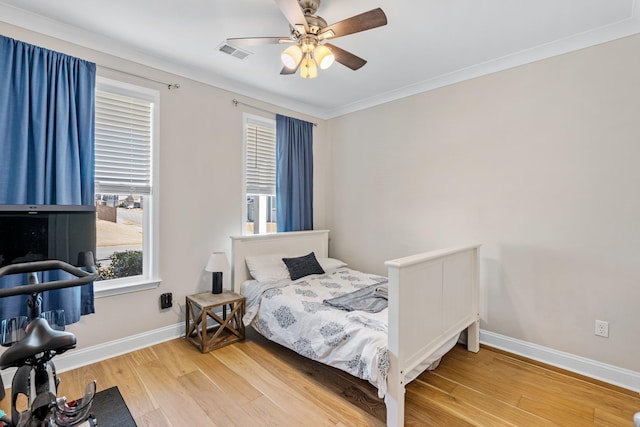 bedroom featuring ceiling fan, light wood finished floors, visible vents, and baseboards