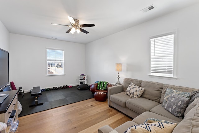 workout room featuring ceiling fan, wood finished floors, visible vents, and baseboards