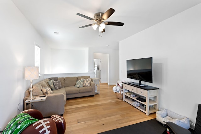 living room with light wood finished floors, ceiling fan, and visible vents