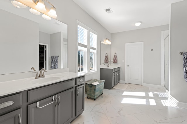 bathroom with two vanities, marble finish floor, visible vents, and a sink