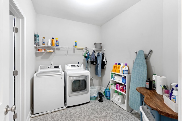 washroom with laundry area, washing machine and dryer, and baseboards