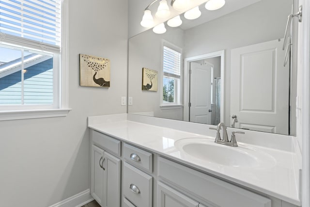 full bath featuring vanity and baseboards