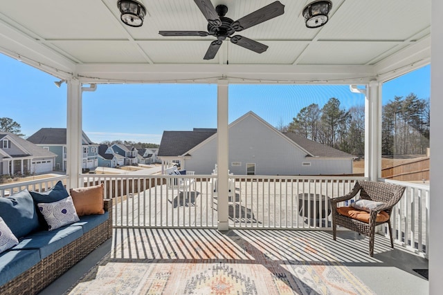 wooden terrace with ceiling fan, outdoor lounge area, and a residential view