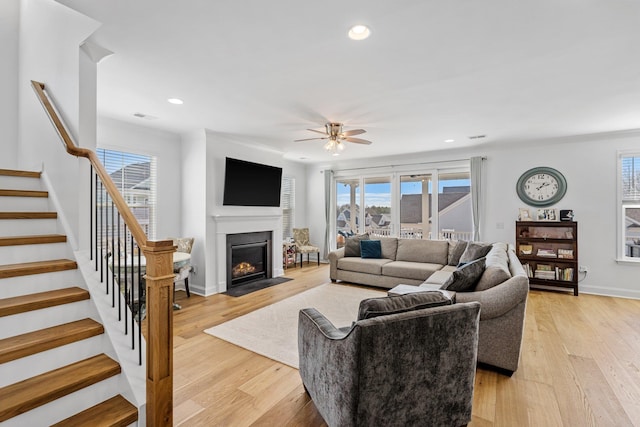 living area with stairs, a wealth of natural light, and light wood-style flooring