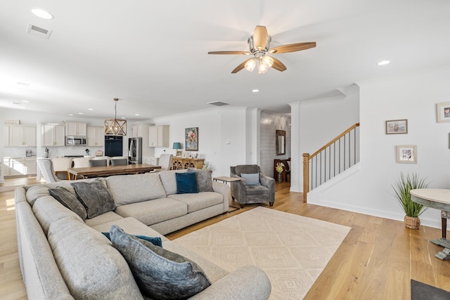 living area featuring light wood-type flooring, stairs, and recessed lighting