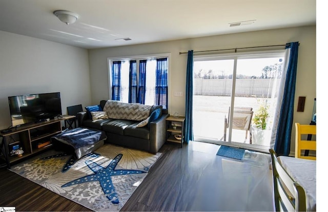 living room featuring visible vents, a wealth of natural light, and wood finished floors