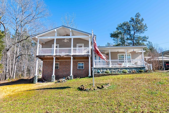 rear view of property with covered porch, brick siding, a ceiling fan, and a yard