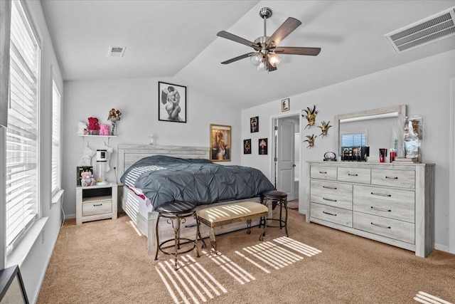 bedroom with lofted ceiling, visible vents, ceiling fan, and light carpet