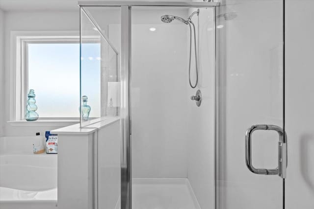 bathroom featuring a shower stall and a bath