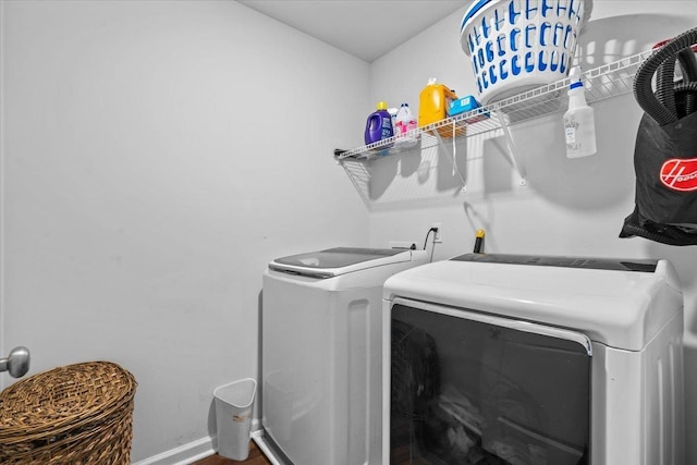 clothes washing area featuring laundry area, washing machine and dryer, and baseboards