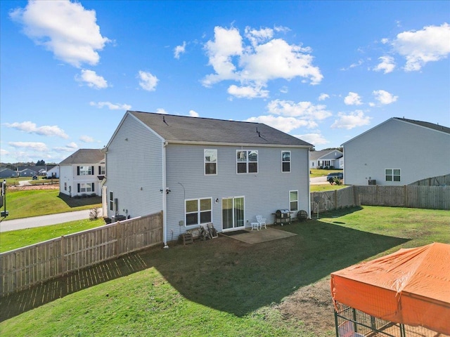 rear view of property with a residential view, a fenced backyard, and a lawn