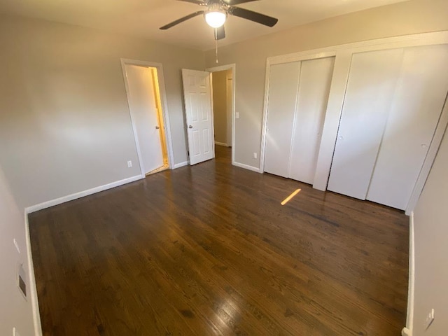 unfurnished bedroom with dark wood-style floors, ceiling fan, baseboards, and a closet