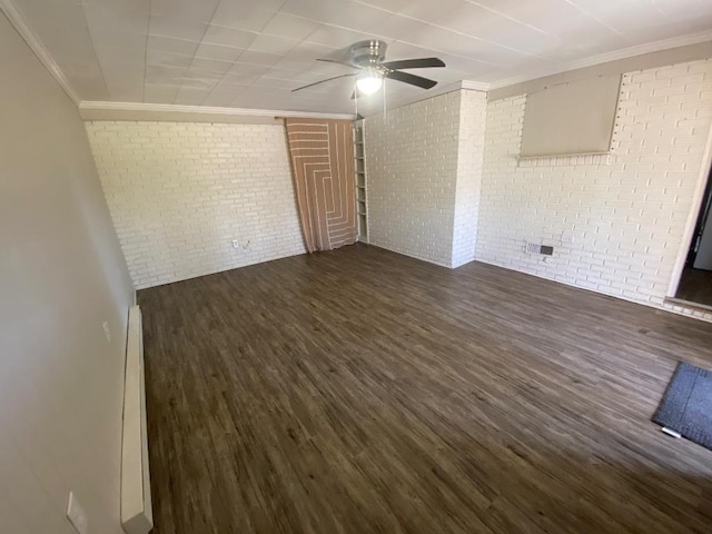 unfurnished room featuring brick wall, baseboard heating, dark wood finished floors, and crown molding