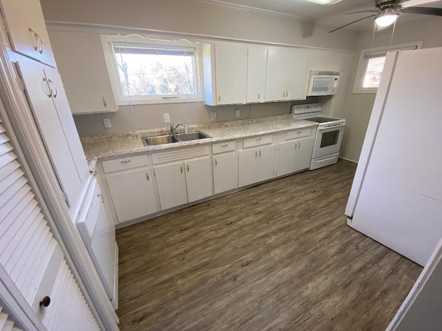 kitchen with white appliances, a sink, white cabinets, light countertops, and dark wood-style floors