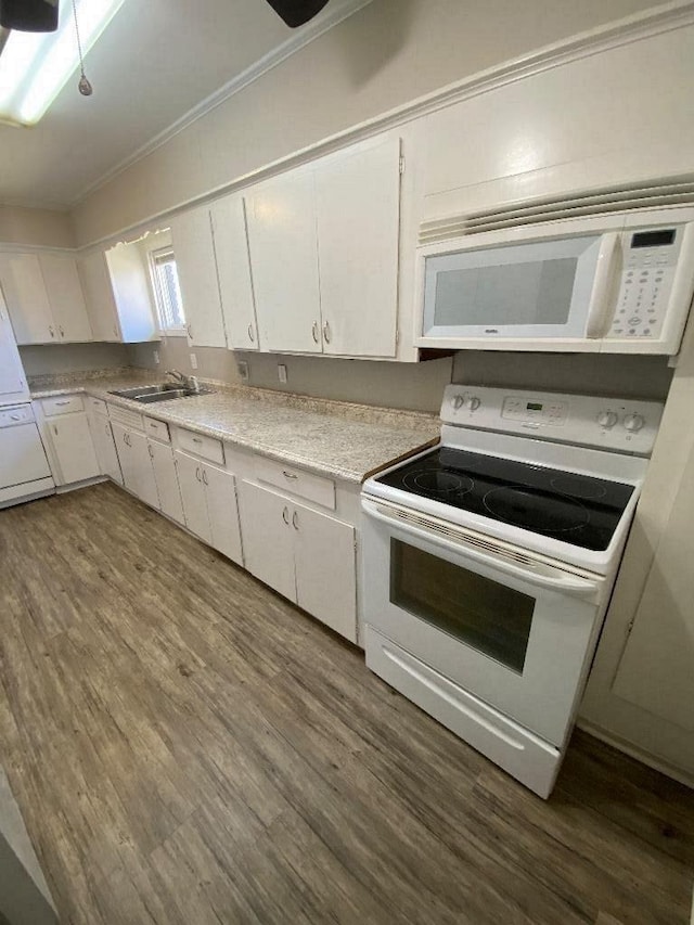 kitchen with a sink, white appliances, dark wood finished floors, and white cabinetry