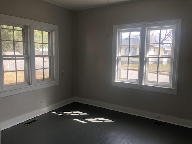 unfurnished room with visible vents, plenty of natural light, and baseboards