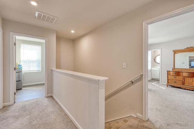 hallway with carpet floors, recessed lighting, visible vents, an upstairs landing, and baseboards