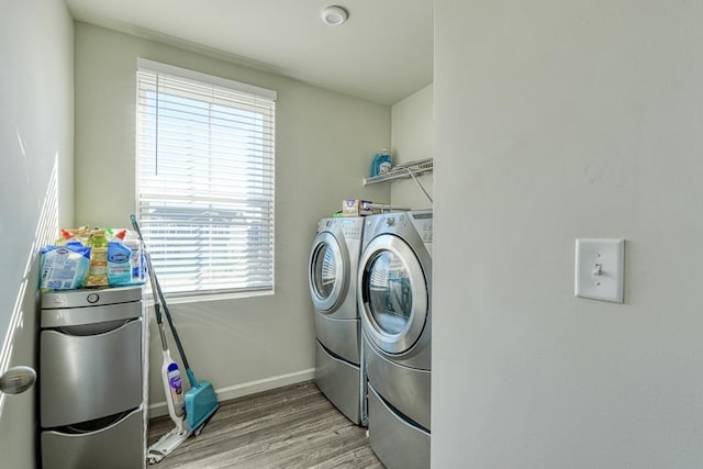 laundry room featuring light wood-style floors, laundry area, independent washer and dryer, and baseboards