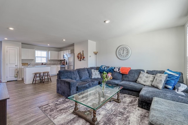 living room with light wood-type flooring and recessed lighting