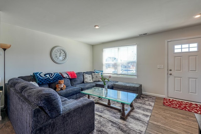 living room featuring wood finished floors, visible vents, and baseboards