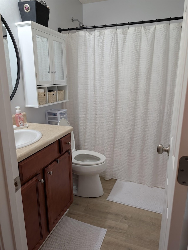 bathroom featuring vanity, wood finished floors, toilet, and a shower with curtain