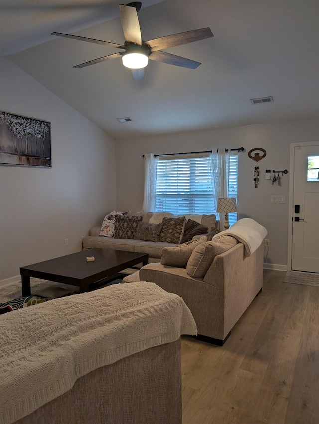 living area with a wealth of natural light, visible vents, and light wood finished floors