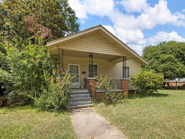 bungalow-style home featuring a front yard and covered porch