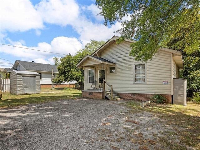 119 Poplar St, Clinton, SC 29325 - view of front facade featuring crawl space, an outdoor structure, and a storage shed