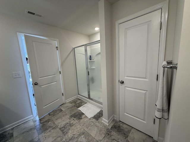 bathroom featuring a stall shower, visible vents, and baseboards