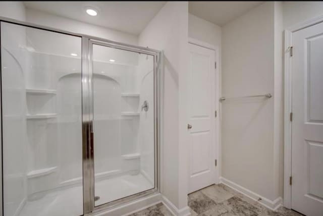 bathroom featuring a stall shower and baseboards