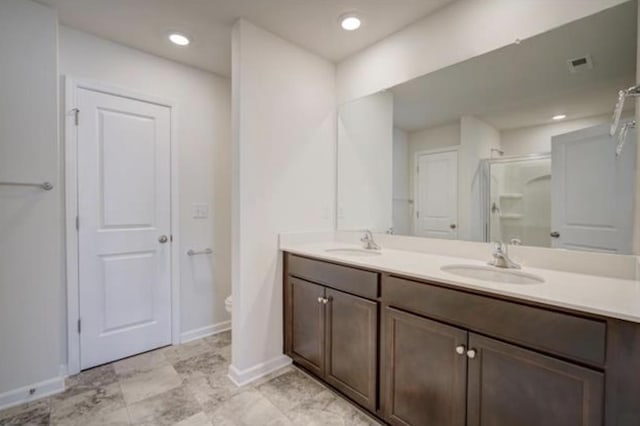 bathroom with double vanity, a stall shower, a sink, and visible vents