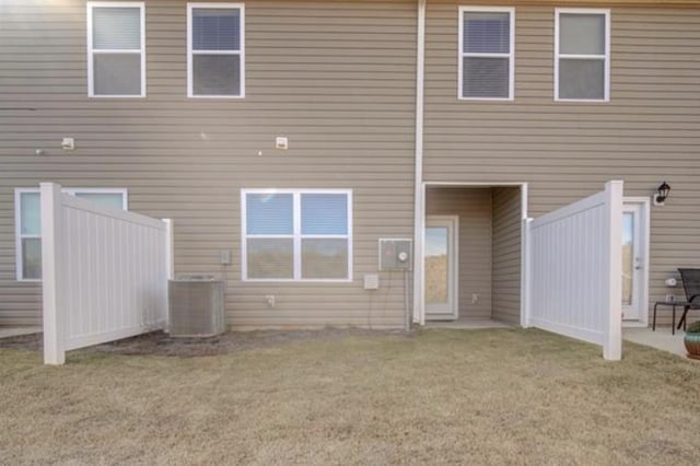 rear view of house with a yard and central air condition unit