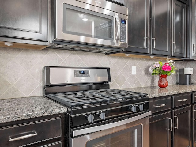 kitchen with light stone countertops, tasteful backsplash, and stainless steel appliances