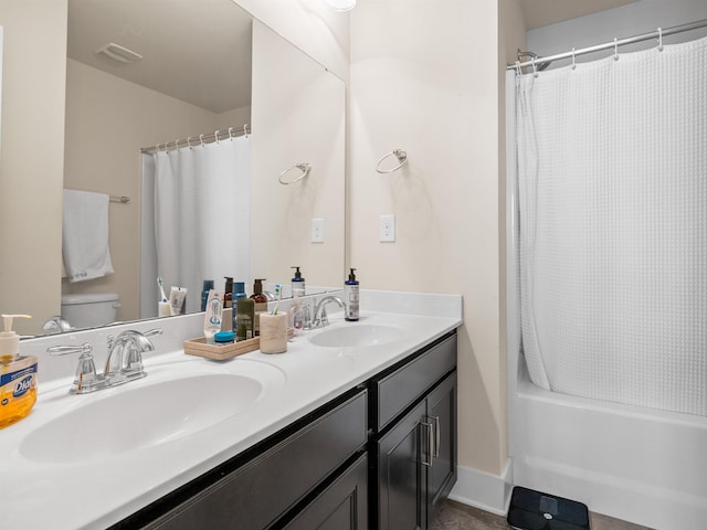 full bath featuring double vanity, shower / tub combo, a sink, and toilet