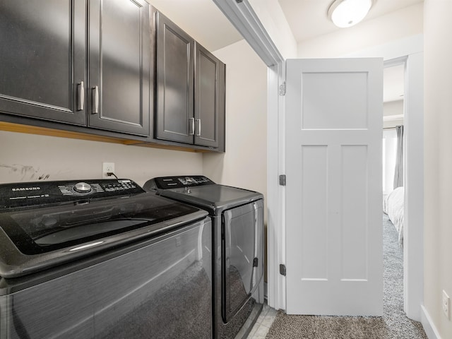 clothes washing area with washer and clothes dryer and cabinet space