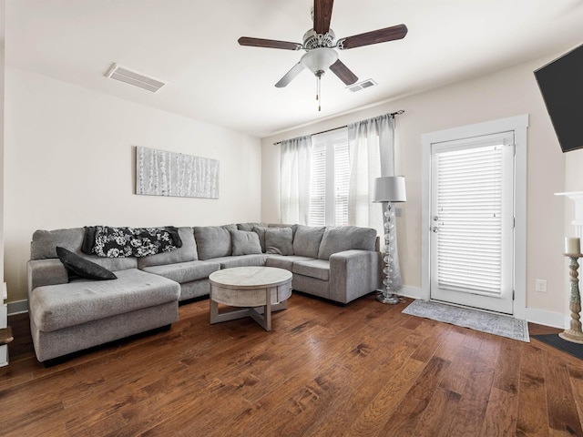 living room with a ceiling fan, baseboards, visible vents, and hardwood / wood-style floors