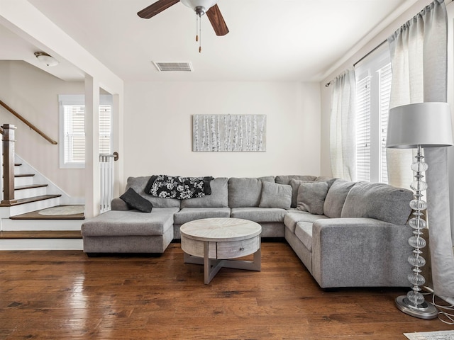 living room with wood-type flooring, visible vents, plenty of natural light, and stairs