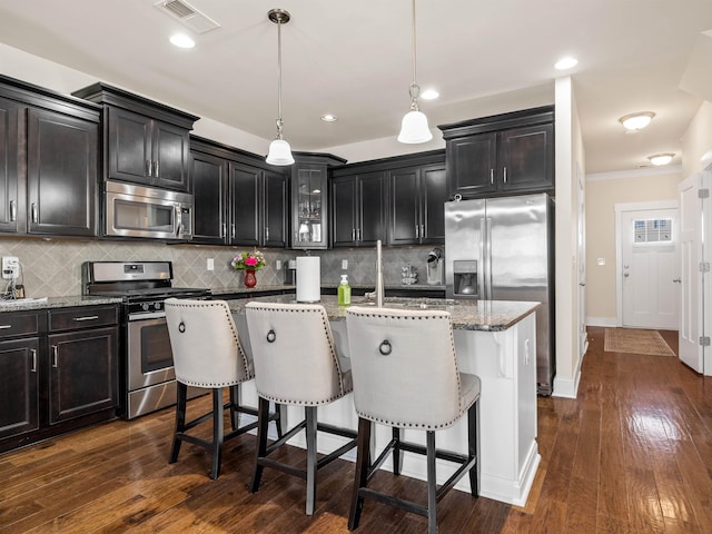 kitchen with a kitchen bar, light stone counters, and stainless steel appliances