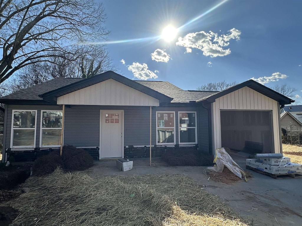 view of front of home featuring a garage and roof with shingles