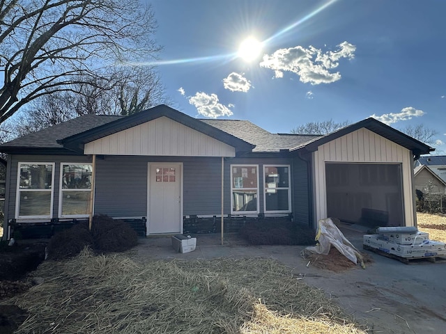 view of front of home featuring a garage and roof with shingles