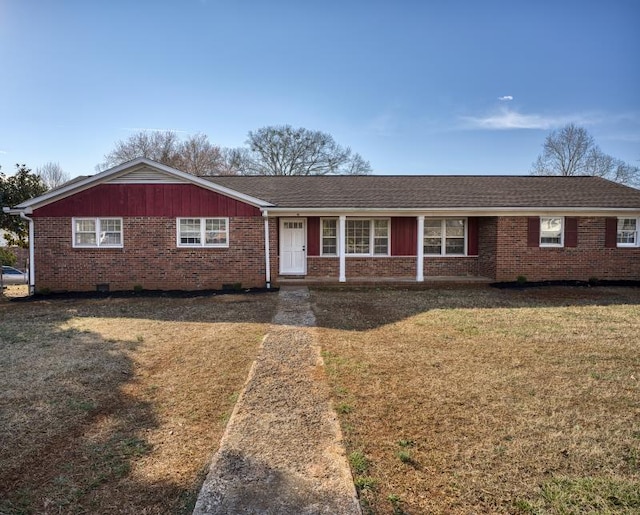 ranch-style house featuring brick siding, a shingled roof, and a front yard