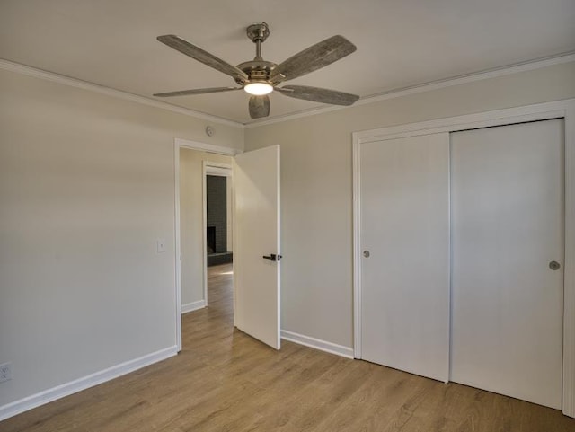 unfurnished bedroom featuring ornamental molding, a closet, light wood-style flooring, and baseboards