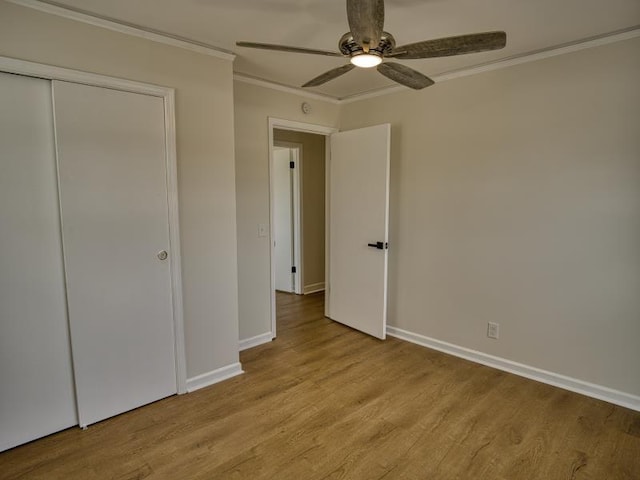 unfurnished bedroom with light wood-style flooring, a ceiling fan, baseboards, ornamental molding, and a closet