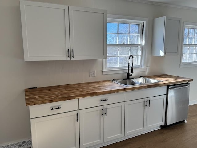 kitchen featuring butcher block countertops, a sink, visible vents, white cabinets, and dishwasher