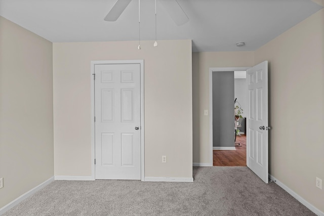 unfurnished bedroom with carpet flooring, a ceiling fan, and baseboards