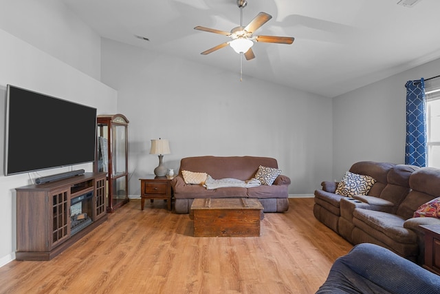 living room with visible vents, baseboards, vaulted ceiling, a ceiling fan, and light wood-style floors