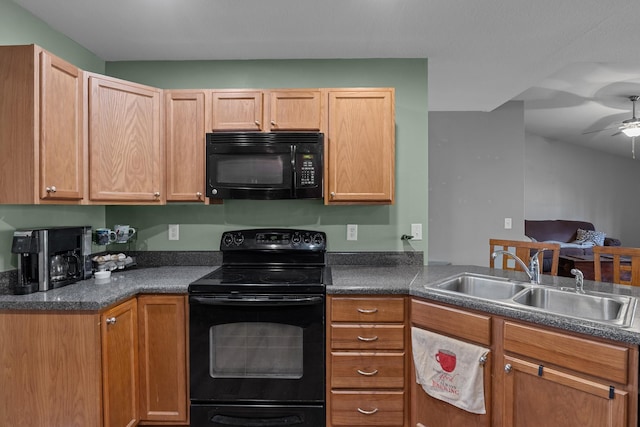 kitchen with dark countertops, black appliances, ceiling fan, and a sink