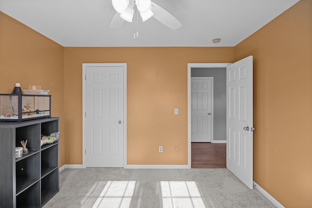 unfurnished bedroom with a ceiling fan, baseboards, and carpet flooring